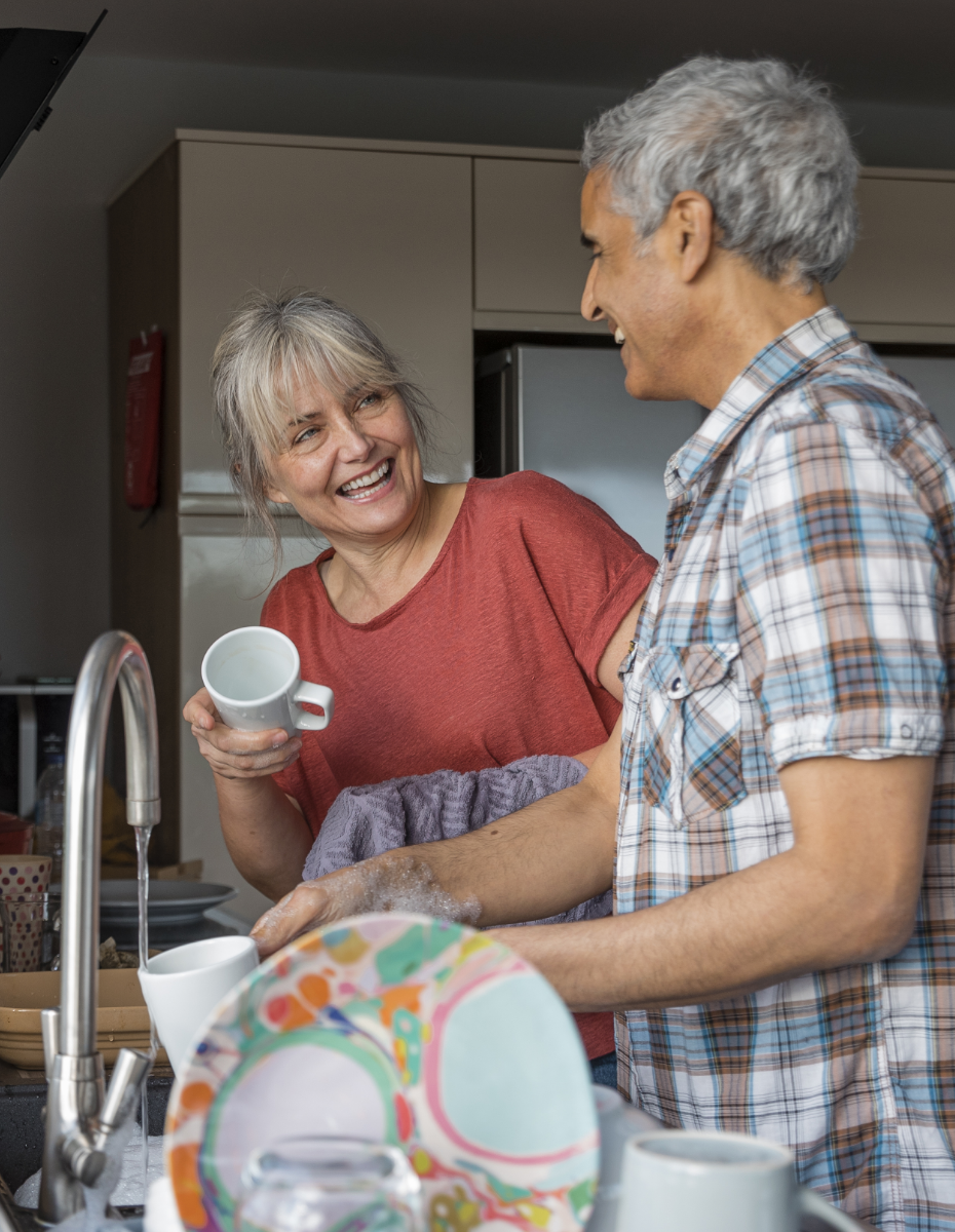 Älteres Paar beim gemeinsamen Abwasch.